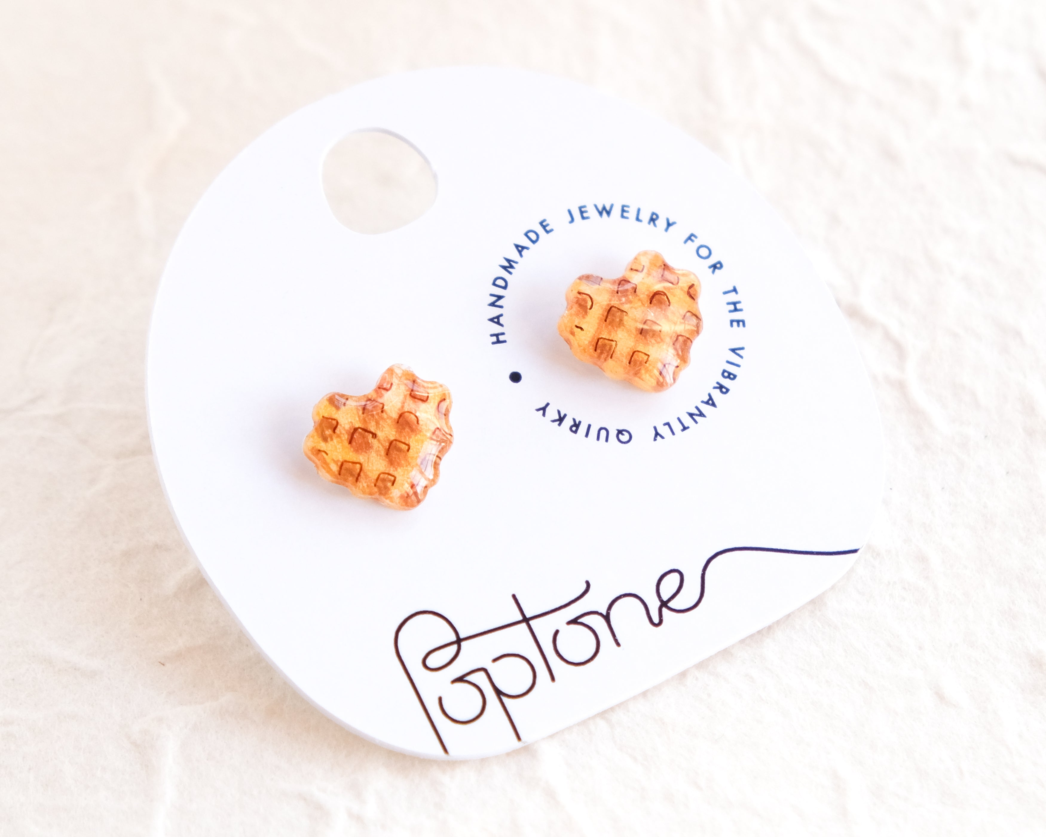 a pair of orange earrings sitting on top of a white plate