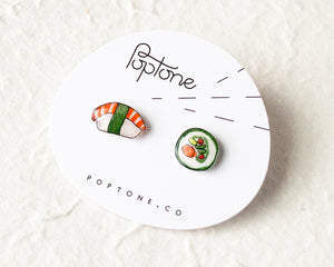 a white plate topped with two sushi earrings