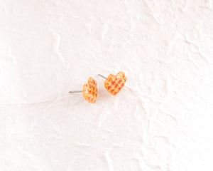 a pair of yellow checkered earrings on a white surface