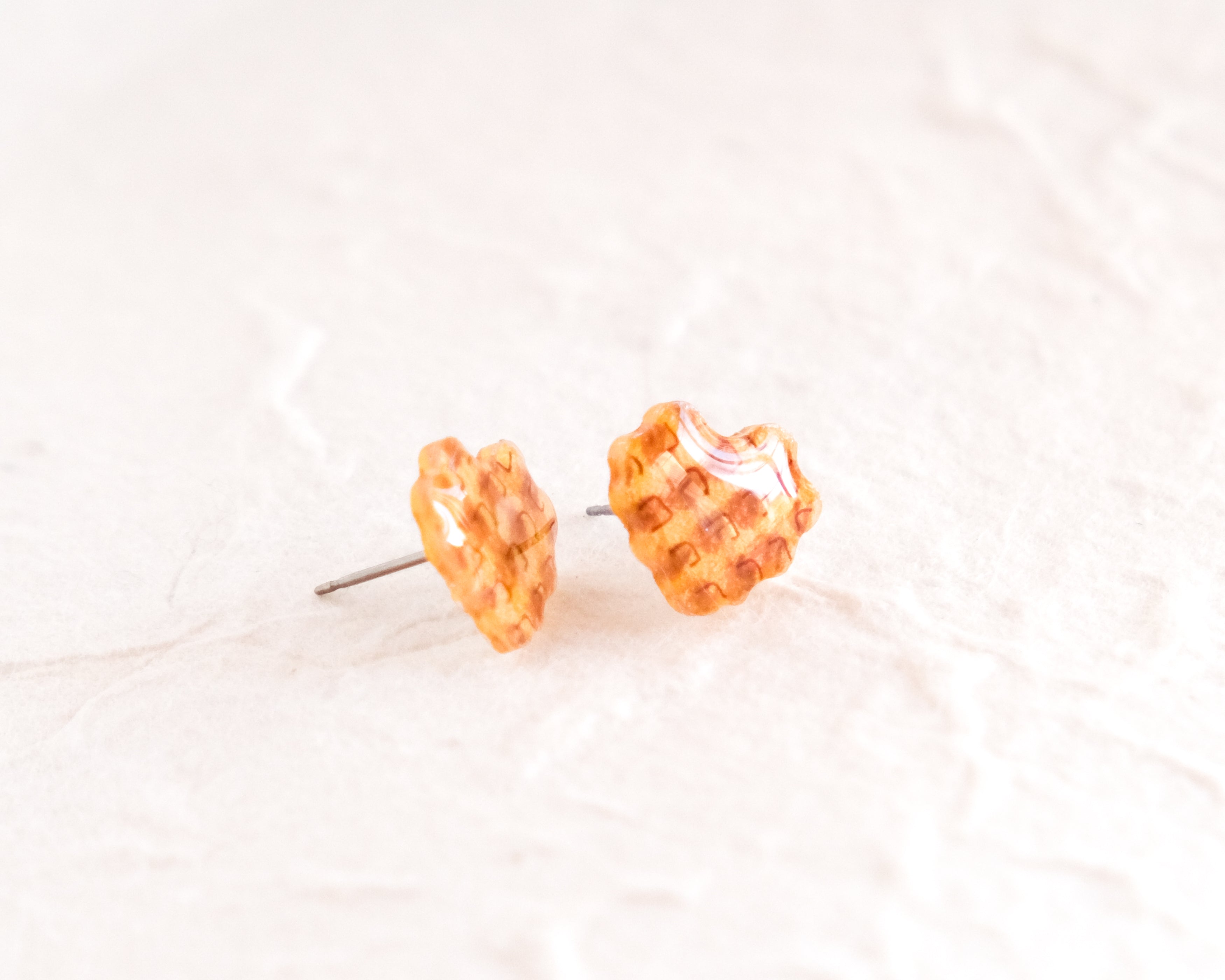 a pair of orange and white checkered earrings