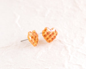 a pair of yellow heart shaped earrings on a white surface