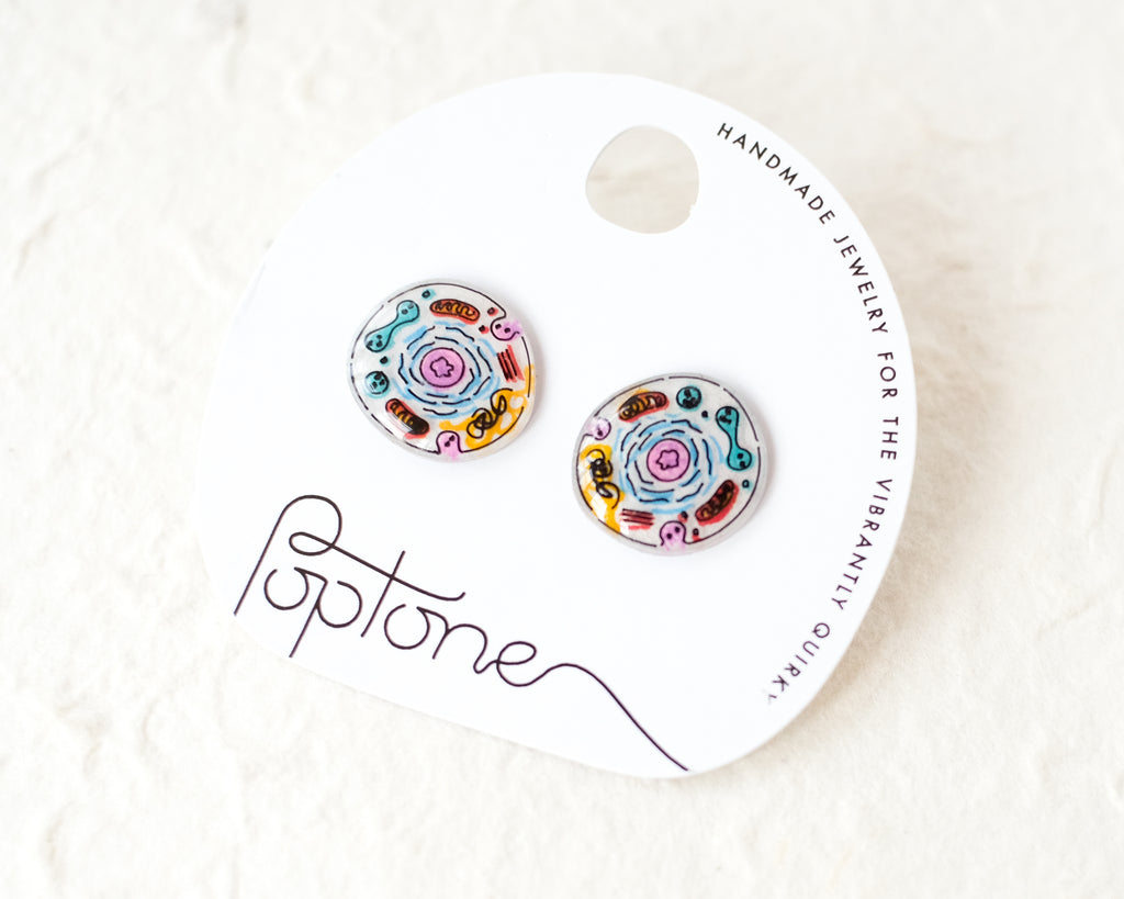 a pair of earrings sitting on top of a white package