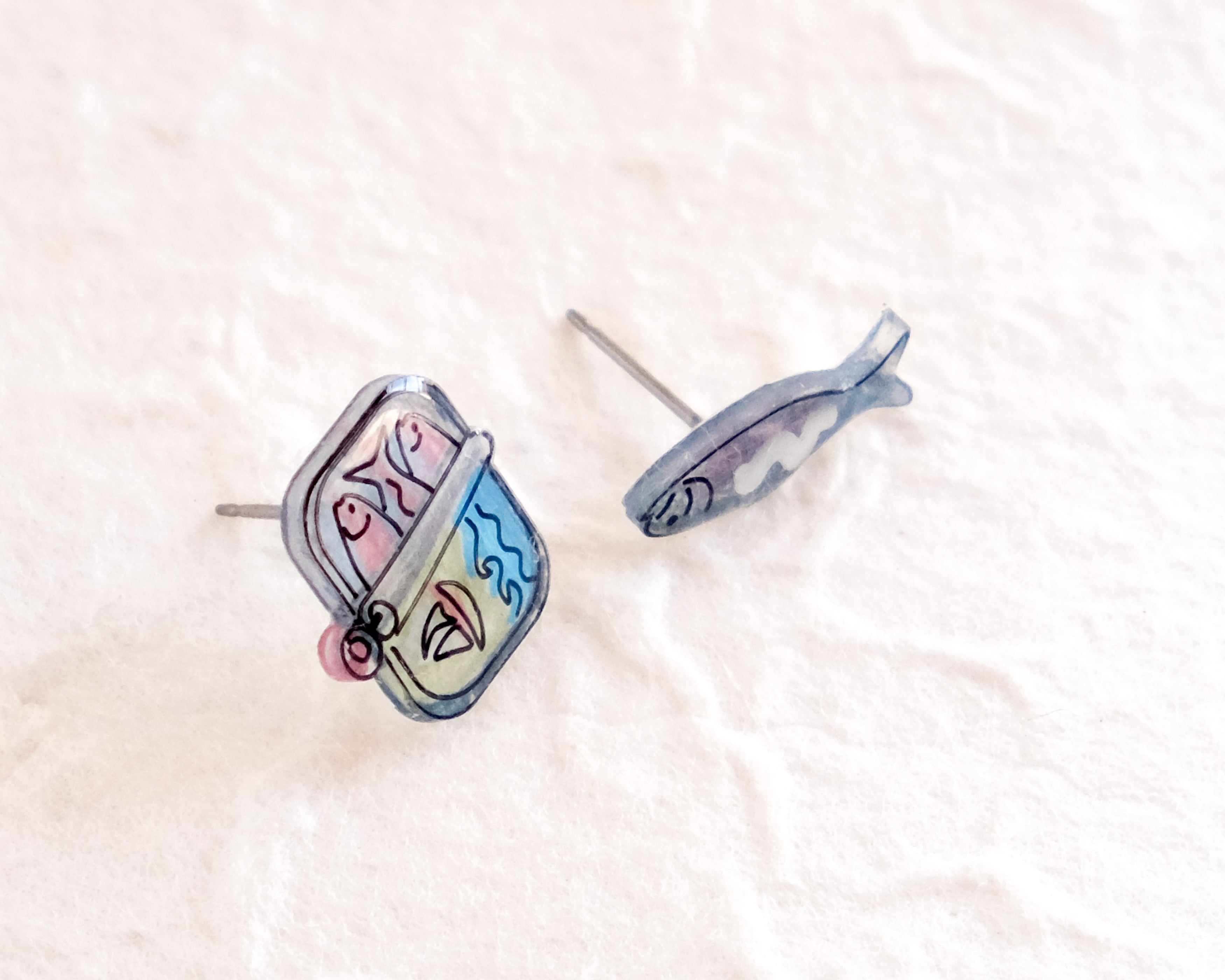 a pair of earrings sitting on top of a white surface