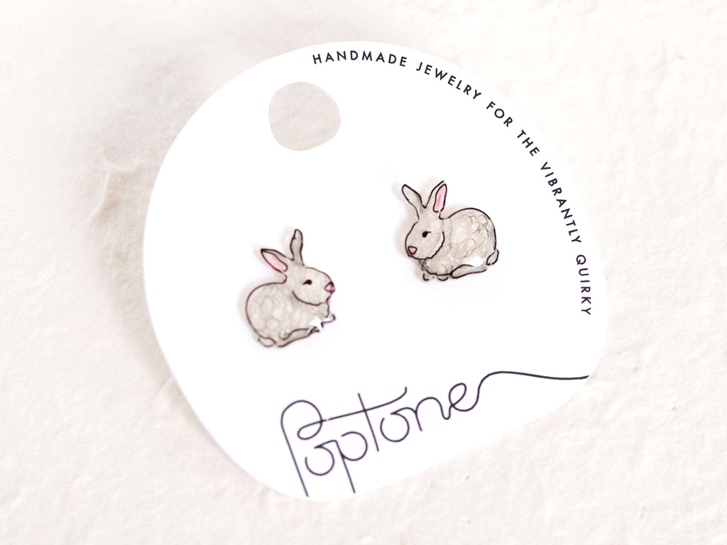a pair of earrings with rabbits on them