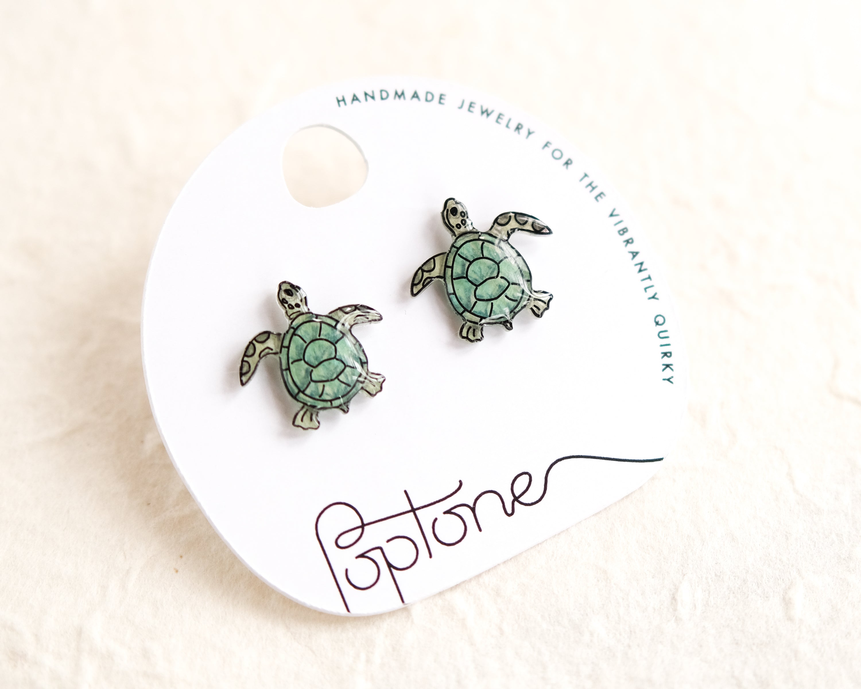 a pair of sea turtle earrings on a white background