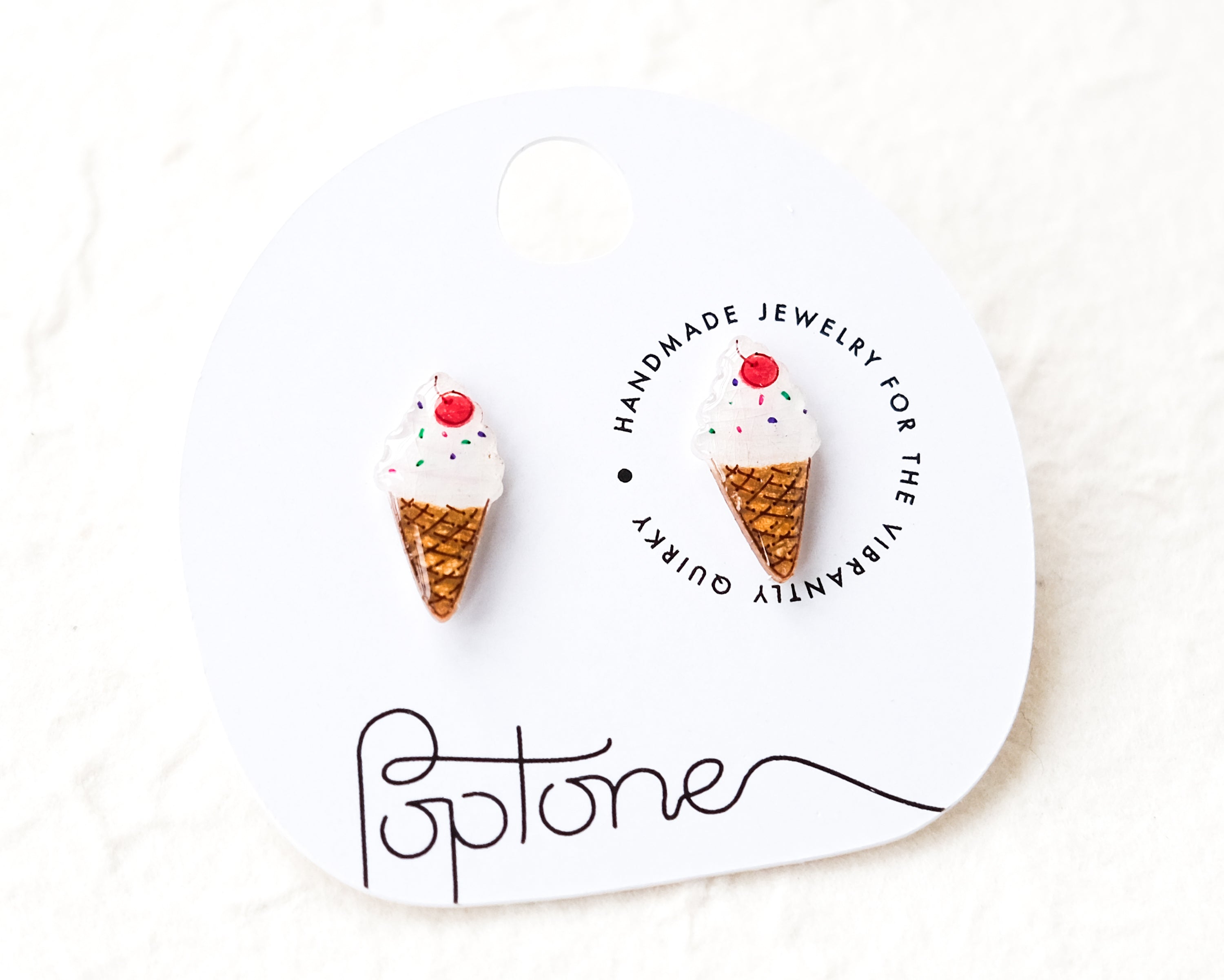 a pair of ice cream cone earrings on a white background