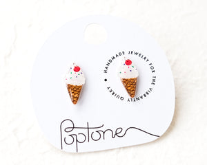 a pair of ice cream cone earrings on a white background