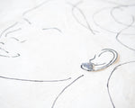 Load image into Gallery viewer, a silver earring with a butterfly design, placed on a white surface with a simple black line drawing of a face.
