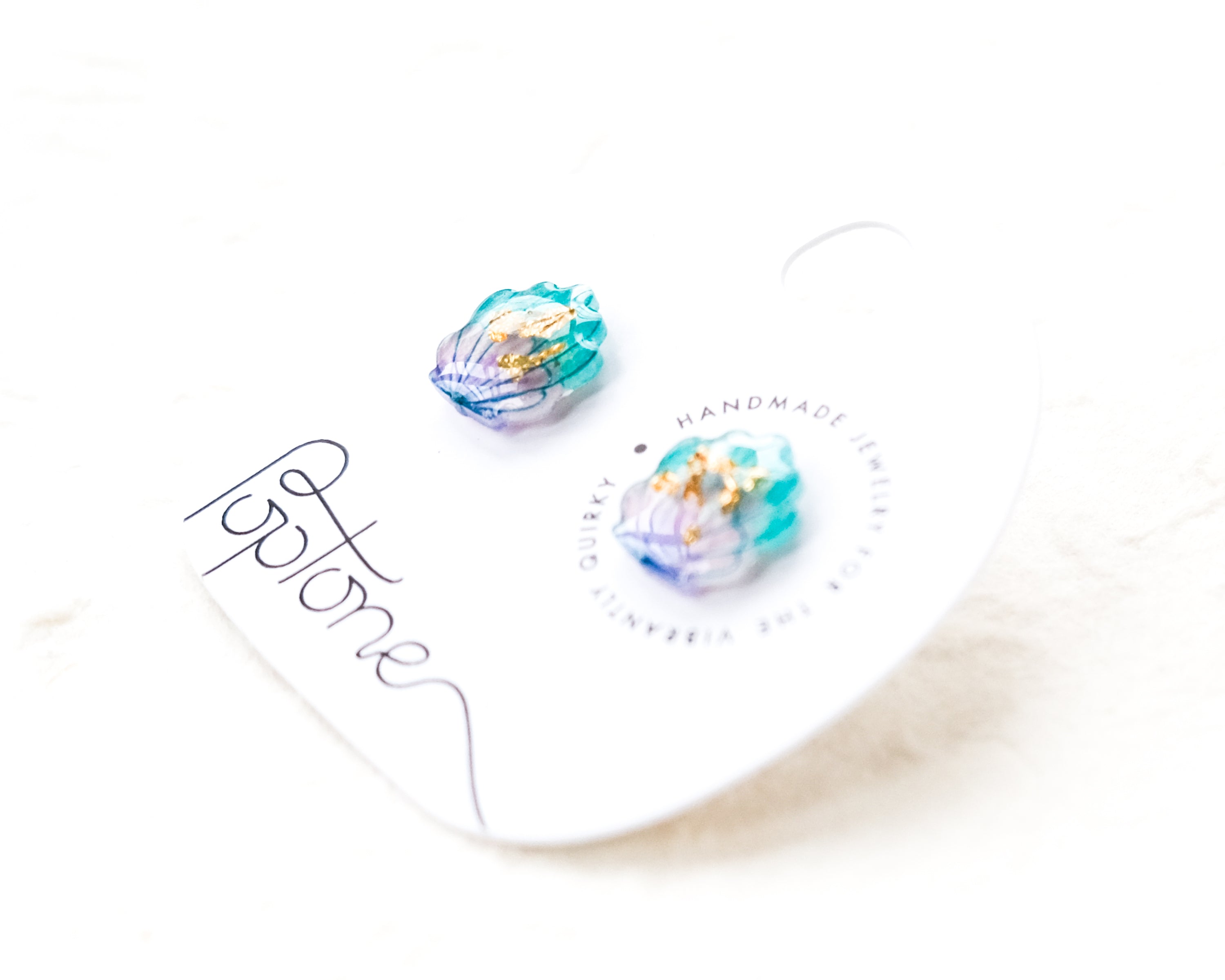a pair of earrings sitting on top of a white plate