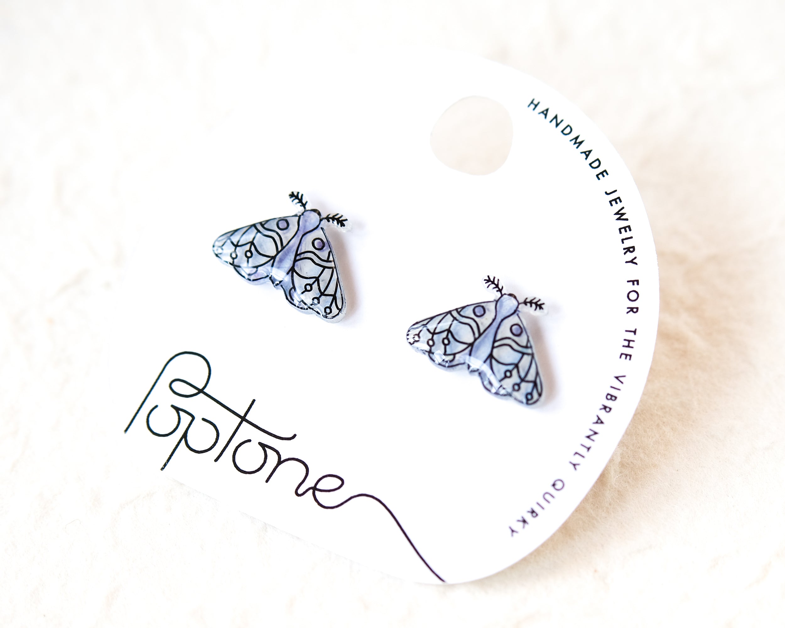 a pair of earrings with a butterfly design, placed on a white background.