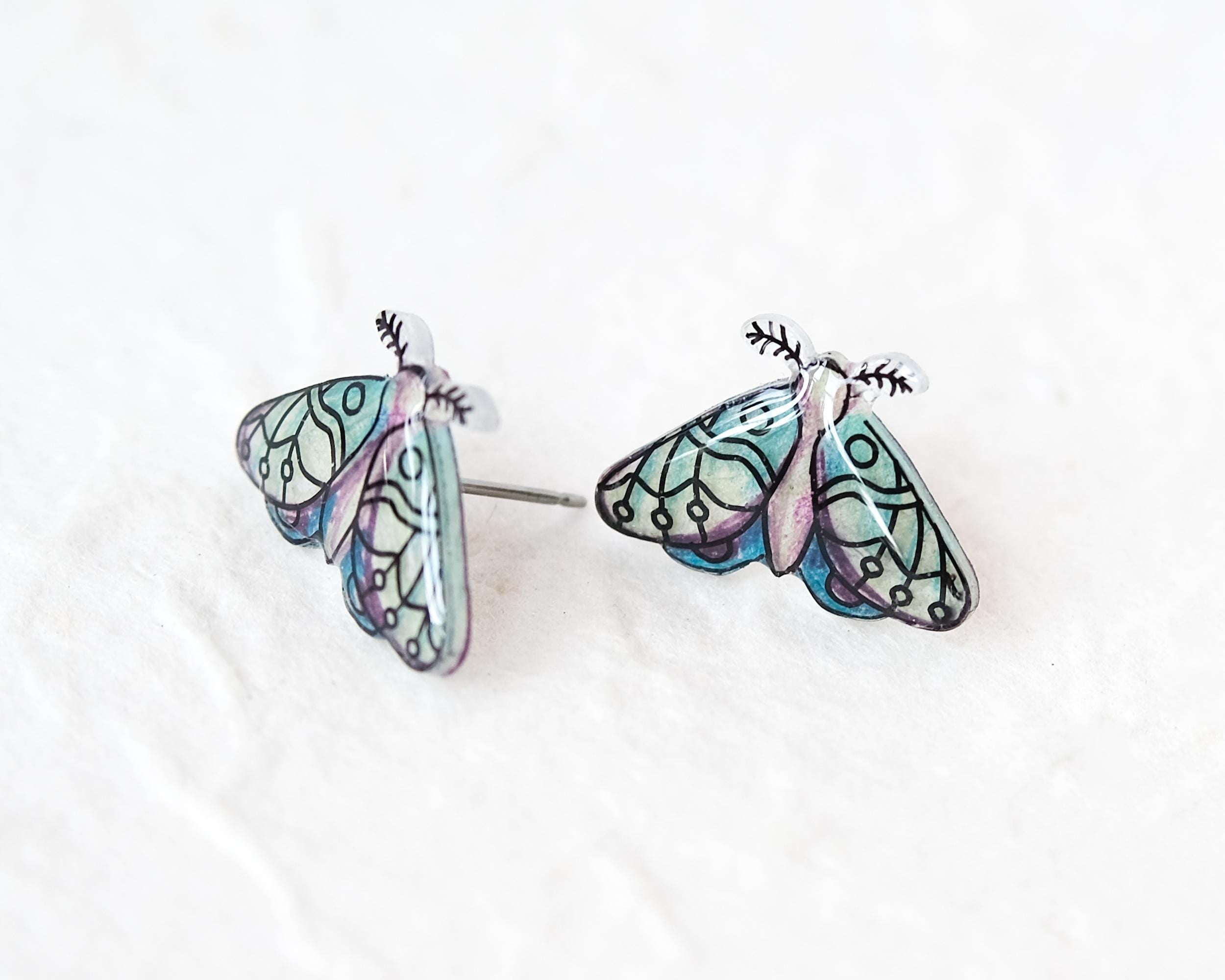 A pair of earrings in the shape of colorful butterflies, with intricate designs and patterns.