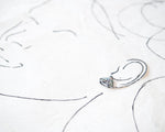 Load image into Gallery viewer, a close-up view of a small, intricately designed earring with a floral pattern.
