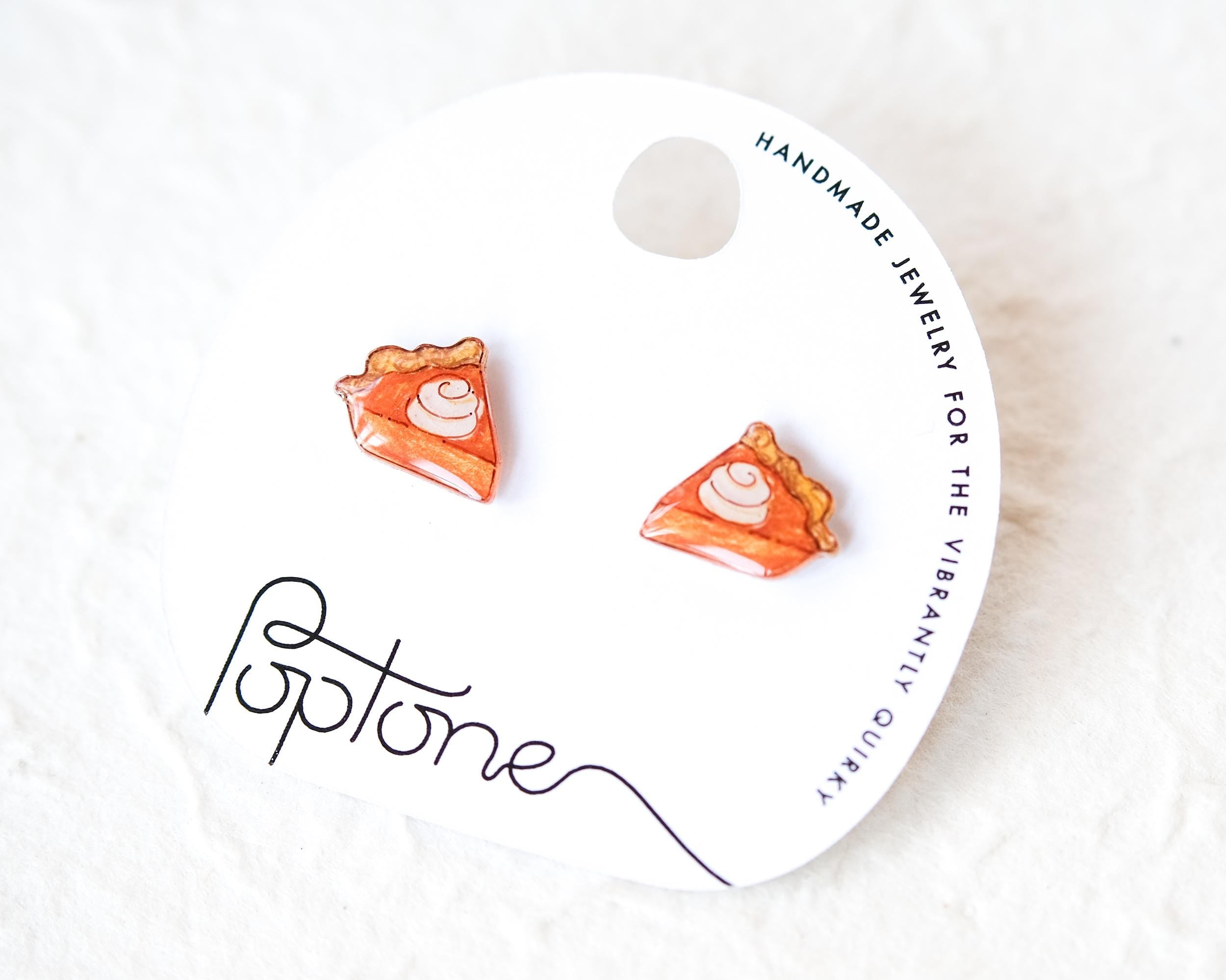 A pair of earrings shaped like slices of pie, with a label that reads "Handmade Jewelry for the Vibrantly Quirky"