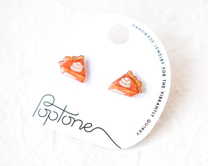 a pair of earrings with a pumpkin pie design, displayed on a white background.