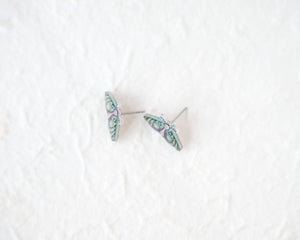 A pair of earrings with butterfly designs on a white background.