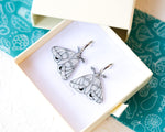 Load image into Gallery viewer, White and Silver Elegant Moth Earrings on Silver Hinged 12 mm Huggie Hoops

