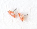Load image into Gallery viewer, A pair of orange-colored earrings with a spiral design on a white background.
