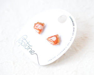 a pair of earrings with a white label that reads "Handmade Jewelry for the Vibrantly Curious".